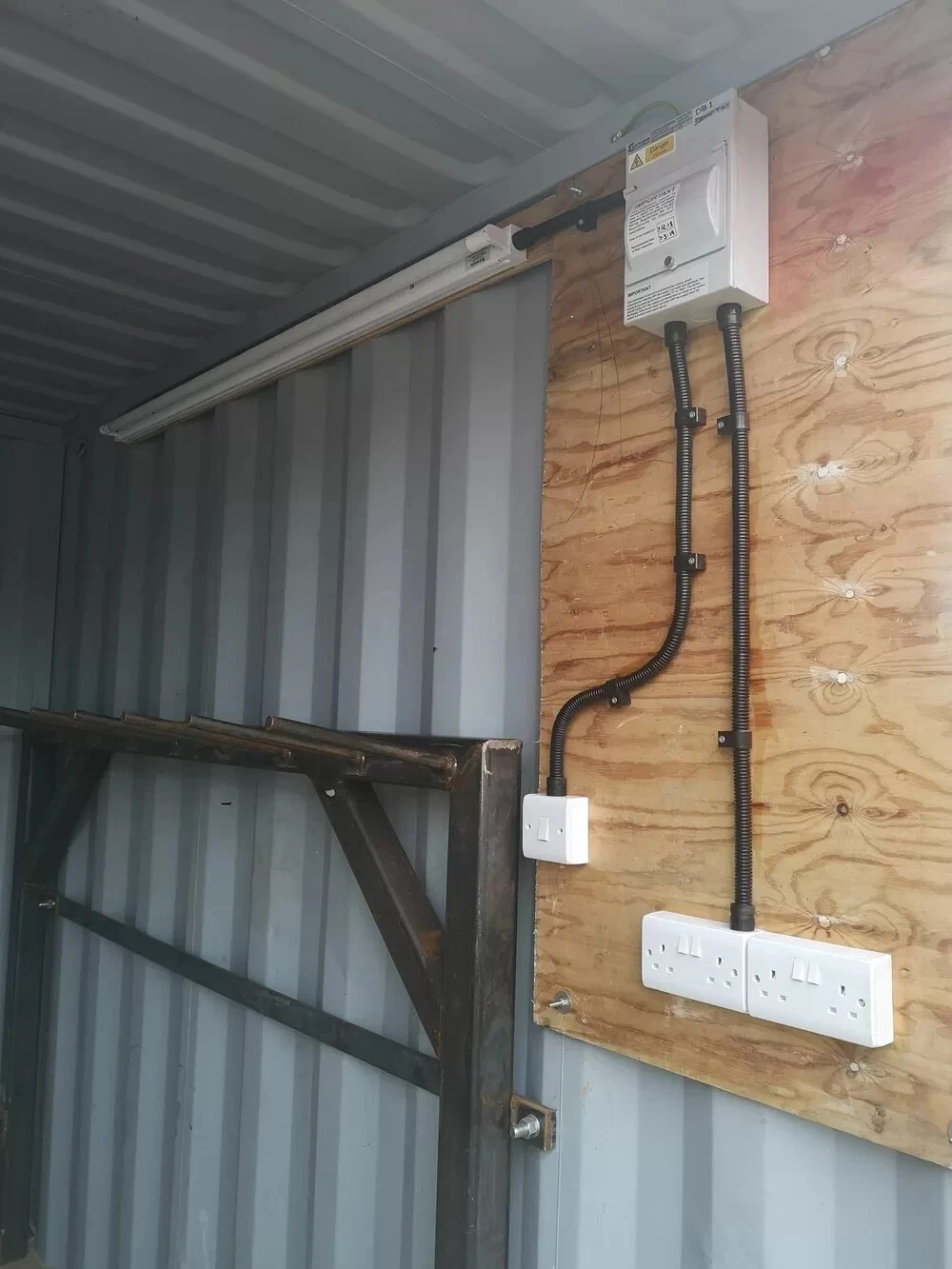 Weather-resistant steel storage container with marine plywood flooring