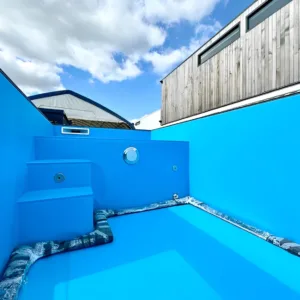 Steel-framed shipping container pool with viewing windows and custom decking