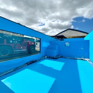 Luxury outdoor container pool with blue liner and glass side panels
