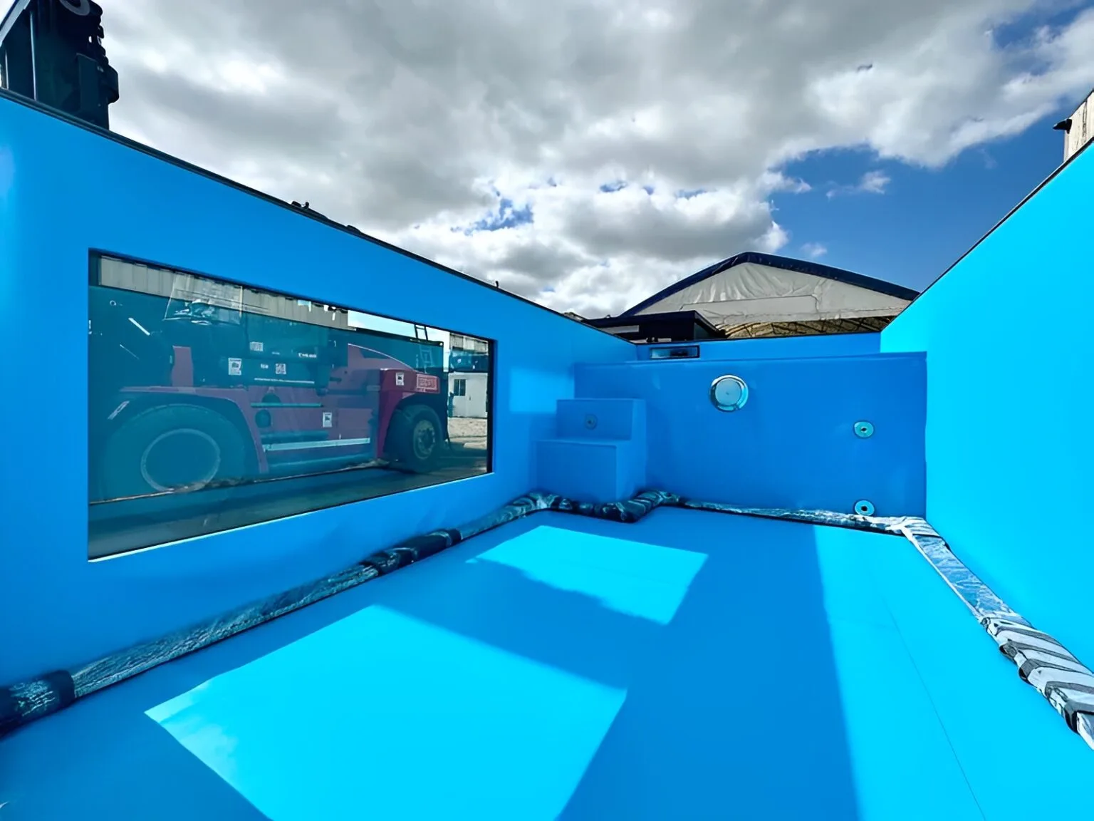 Luxury outdoor container pool with blue liner and glass side panels