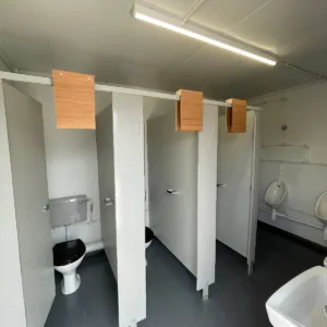 Portable toilet block container with wheelchair-accessible restroom compartment