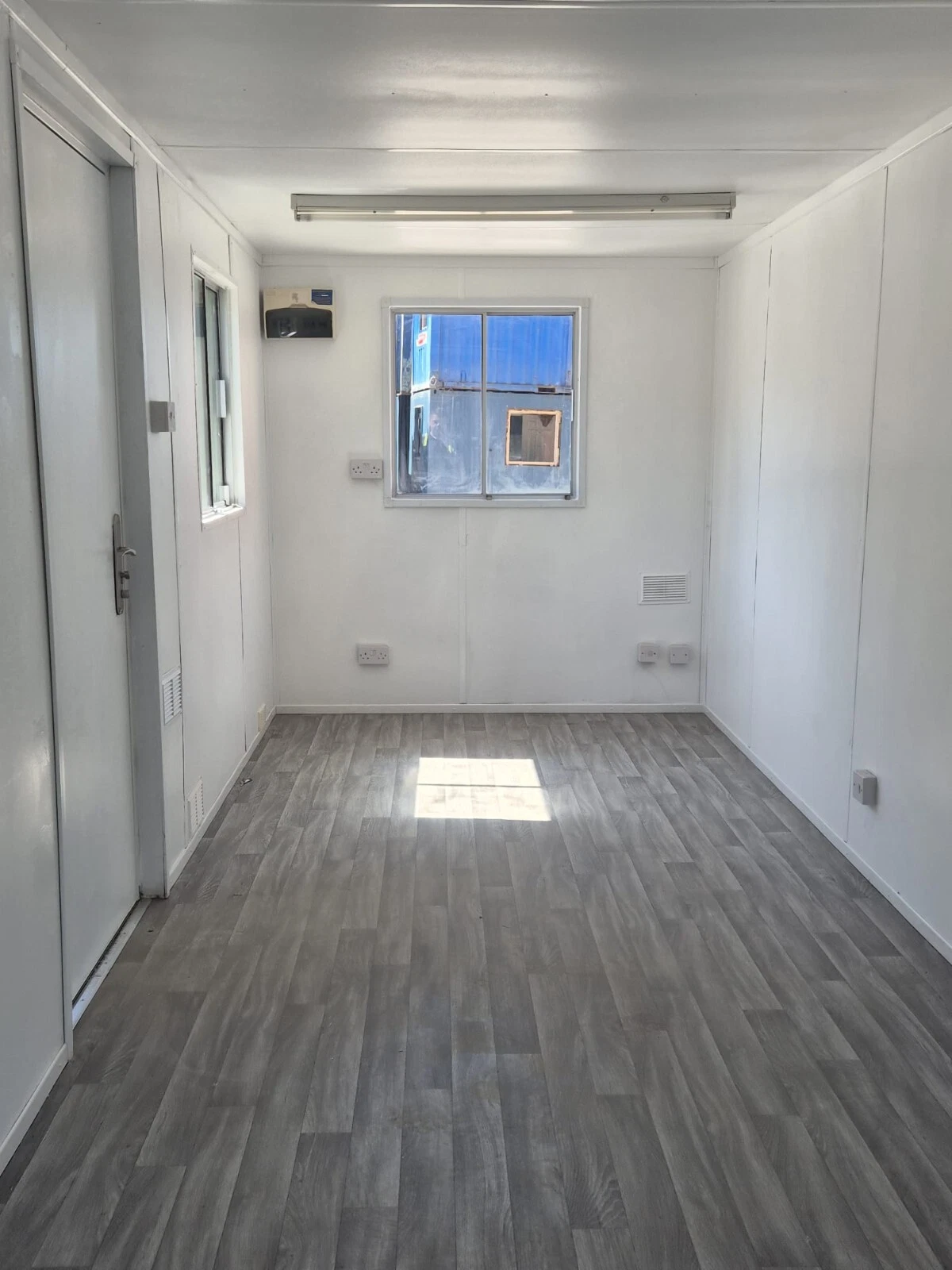 Green office shipping container with insulated interior and LED lighting