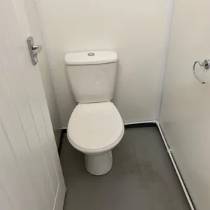 Shipping container bathroom facility with insulated interior and secure access doors
