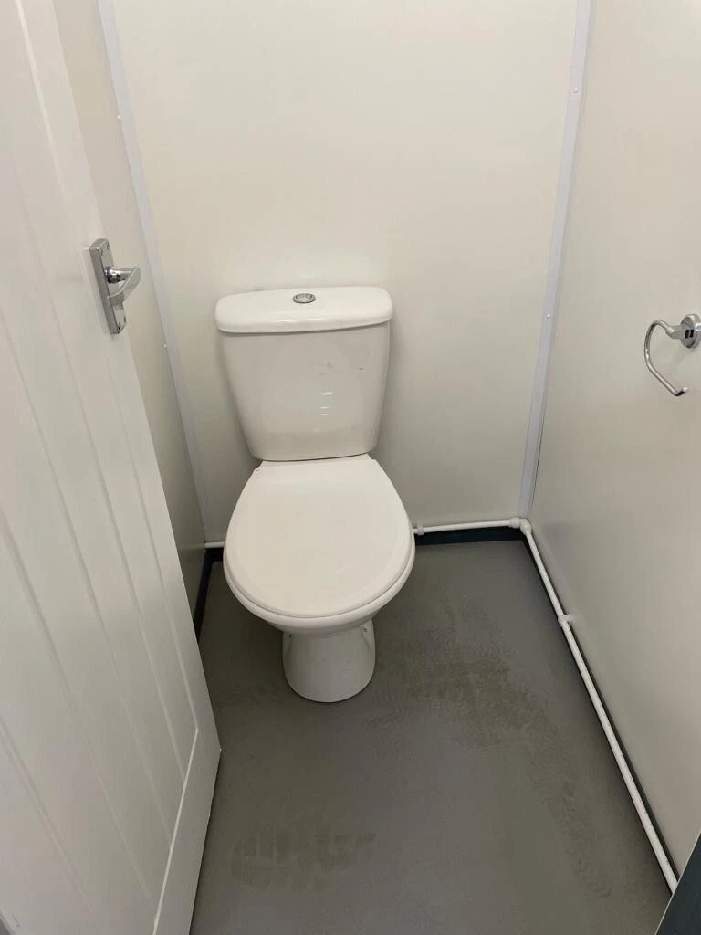 Shipping container bathroom facility with insulated interior and secure access doors