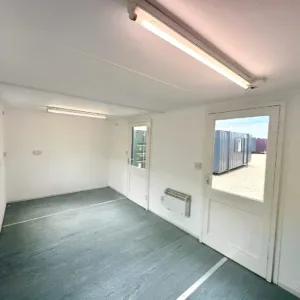 Refurbished site cabin with sliding windows, anti-vandal shutters, and vinyl flooring