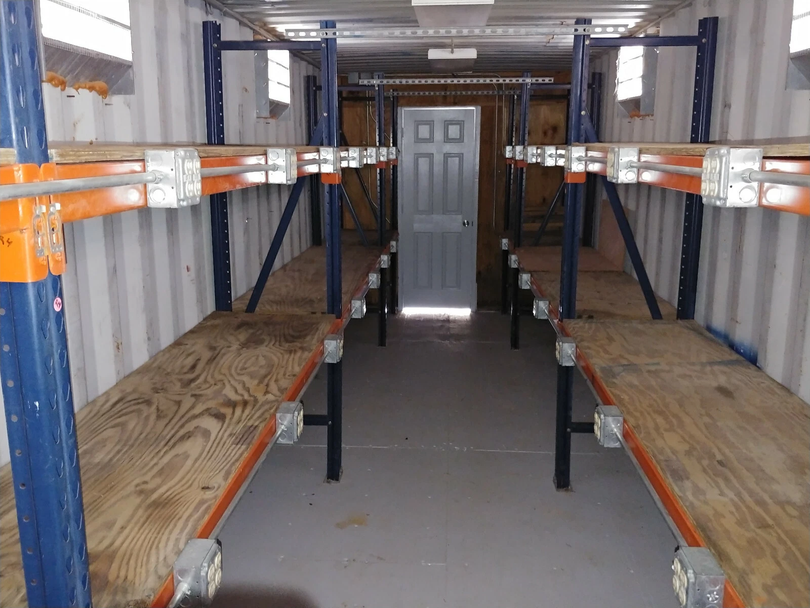 Climate-controlled shipping container office with inventory storage system