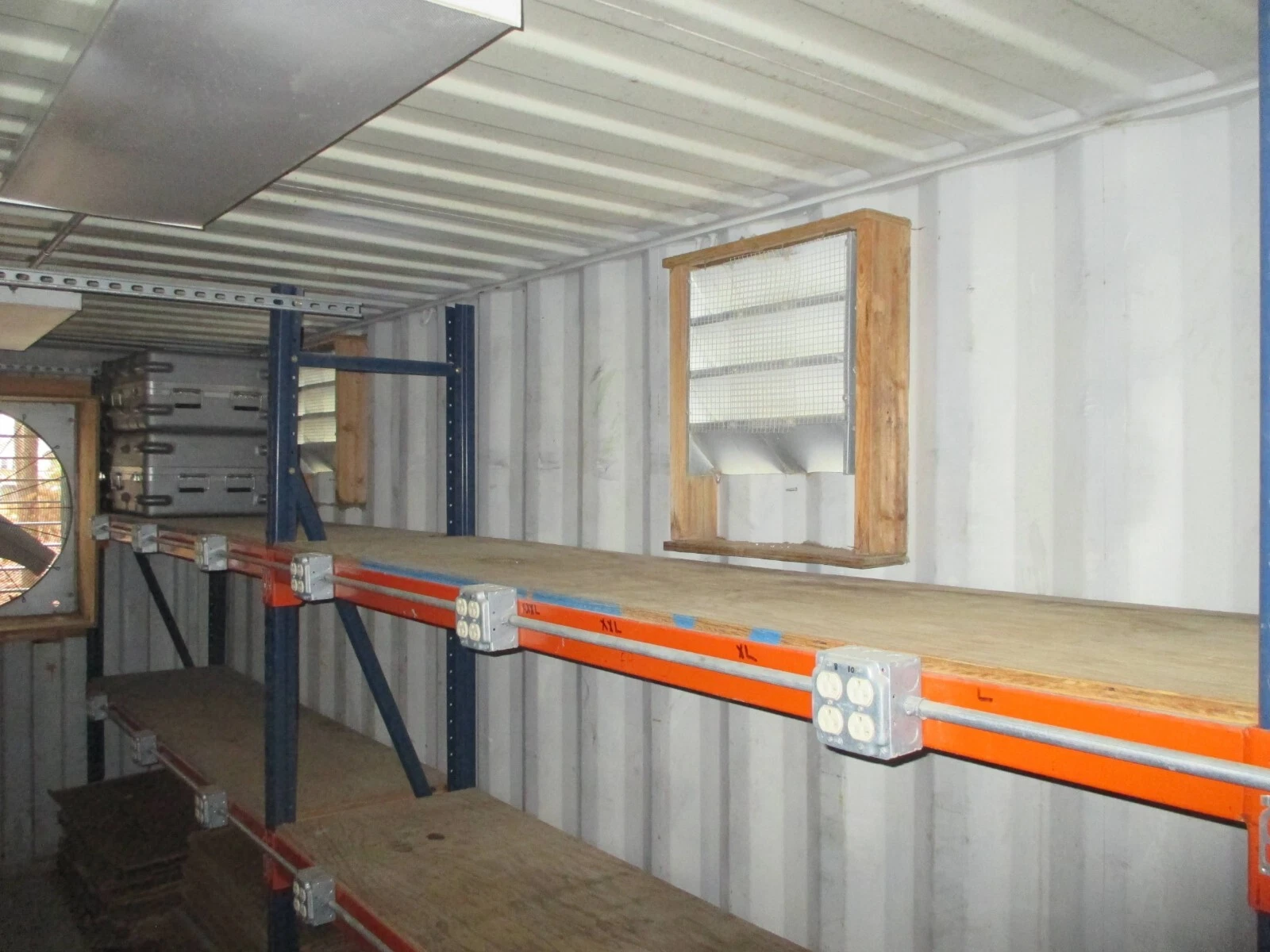 Container office with built-in shelving, electrical installation, and workspace