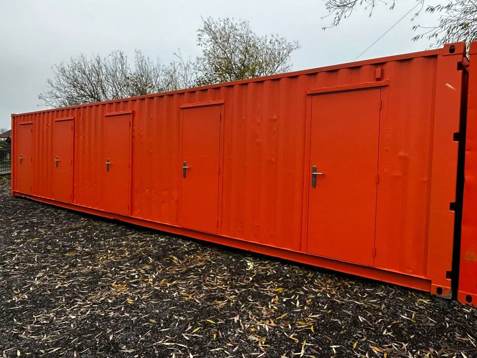 Multi-compartment shipping container with secure side access doors