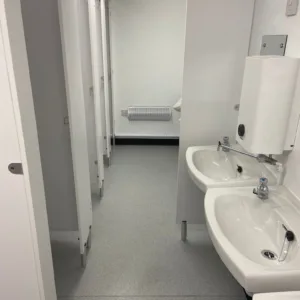 Portable steel toilet cabin with six WC cubicles and one accessible cubicle