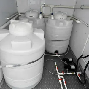 Event restroom trailer with private stalls, sinks, and storage cabinets
